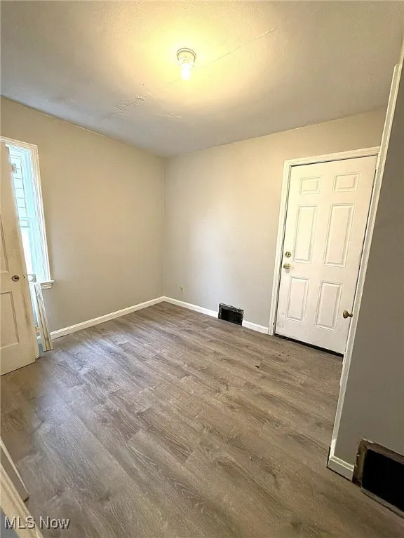 Unfurnished room with baseboards and wood finished floors