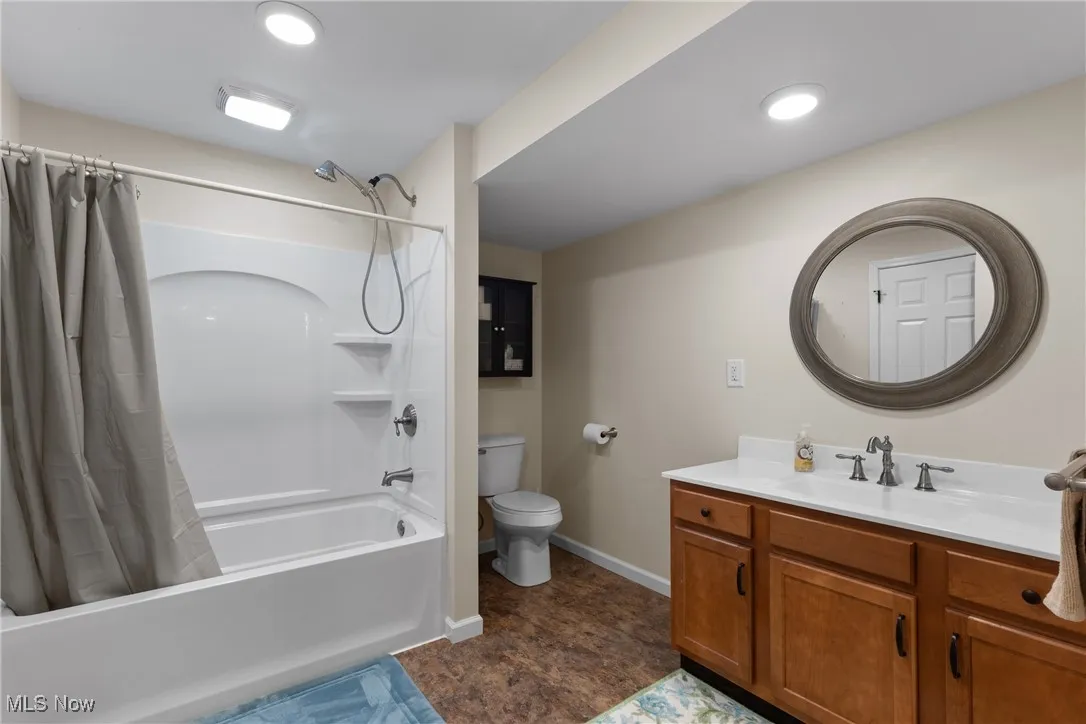 Basement full bath with shower / bathtub combination with curtain, vanity, and recessed lighting