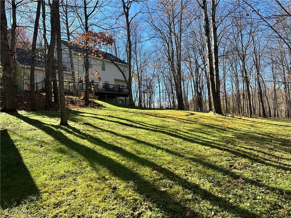 View of green lawn featuring a deck