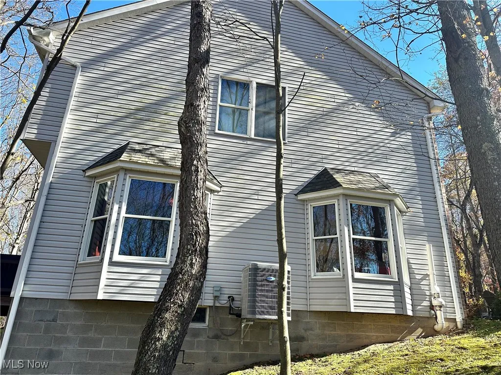 View of side of home with a cooling unit