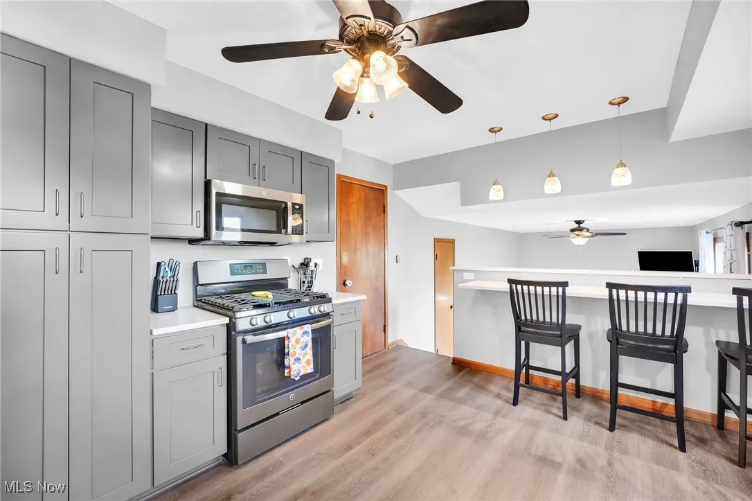 Another view of the kitchen with gas range and breakfast bar