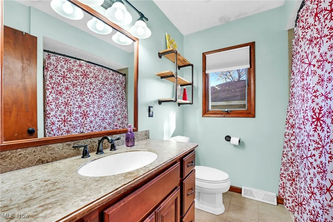 Main full bath with spacious vanity area and linen closet