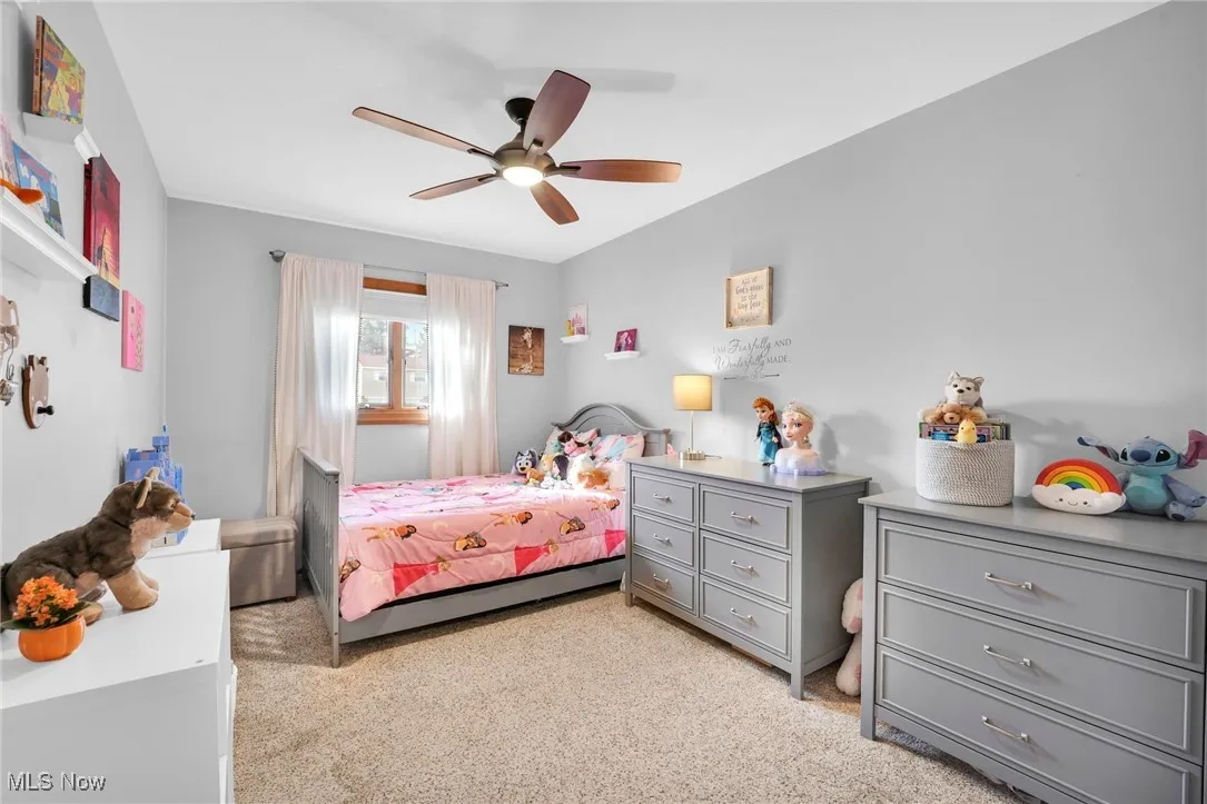 Second bedroom with natural light, carpet and ceiling fan