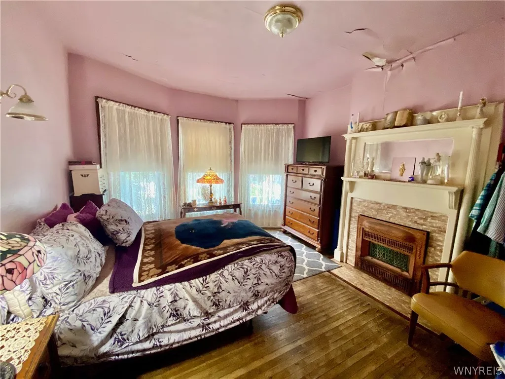 Bedroom #1:  Front of house with bay windows and decorative fireplace.