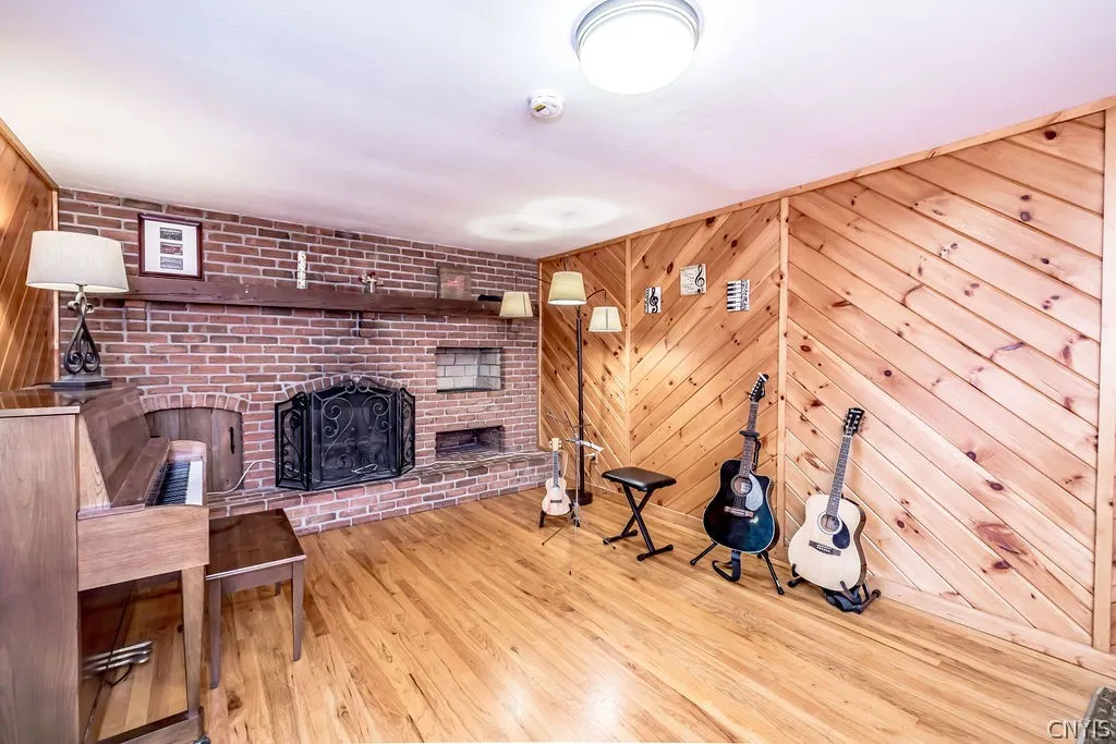 The family room offers  attractive diagonal oak accent walls and a full wall woodburning fireplace.