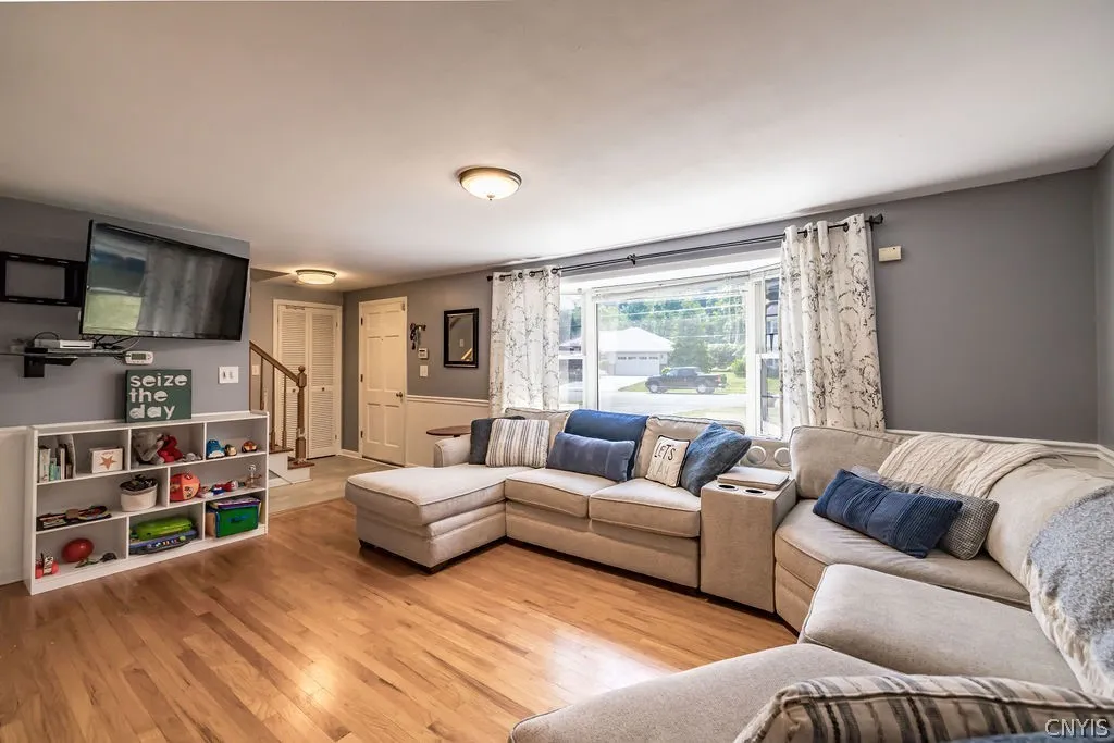 This spacious living room has cool gray walls, a huge picture window and gleaming hardwood floors to enjoy family and guest gatherings.