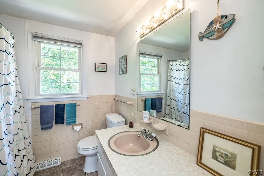 New ceramic tile floor fits in nicely in this retro pale pink full bath.