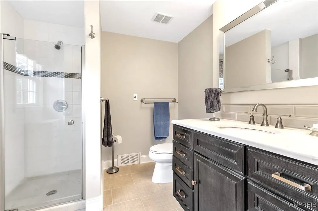 Remodeled primary BD Bath with ceramic tiled shower stall + pretty vanity