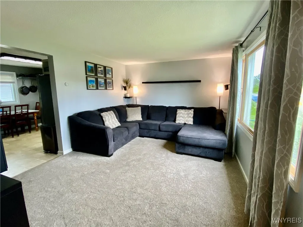 Good sized living room with newer carpeting is open to the kitchen.