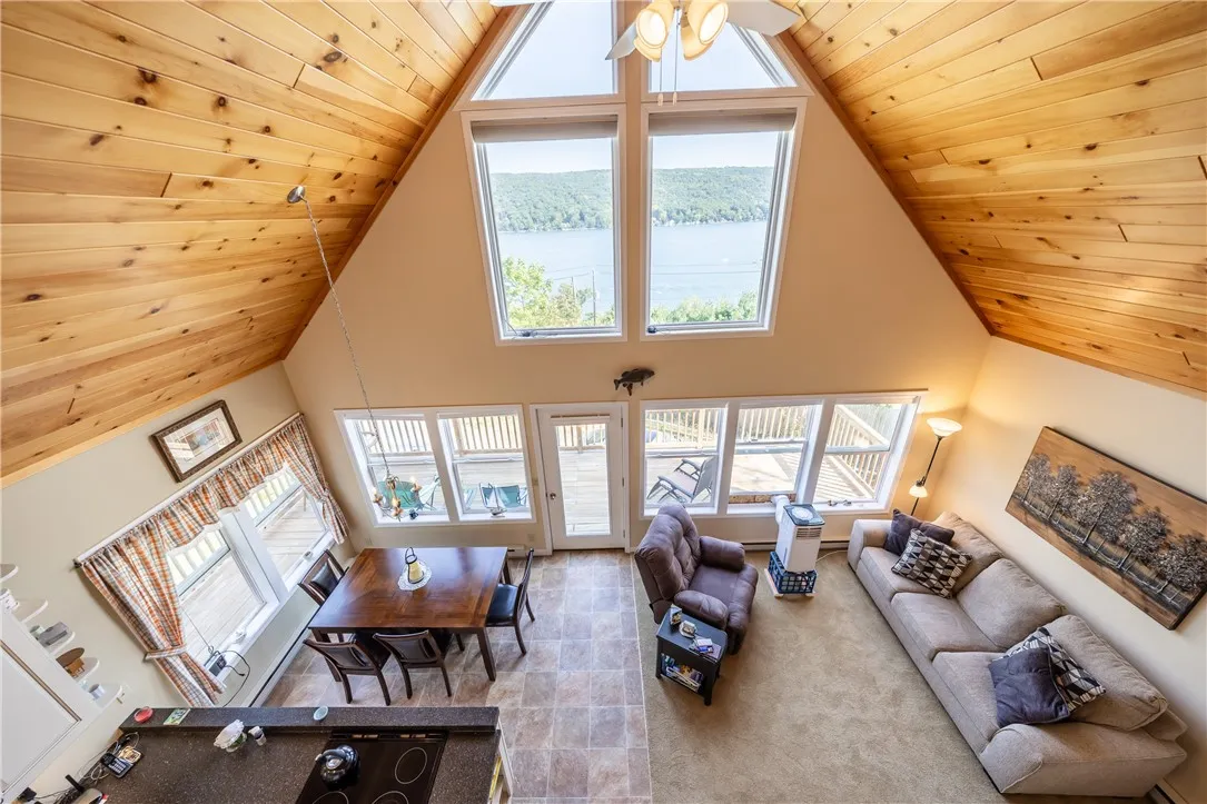 SPECTACULAR TWO STORY GREAT ROOM WITH WOOD CEILINGS & WALL OF WINDOWS FOR PANORAMIC LAKE VIEWS!