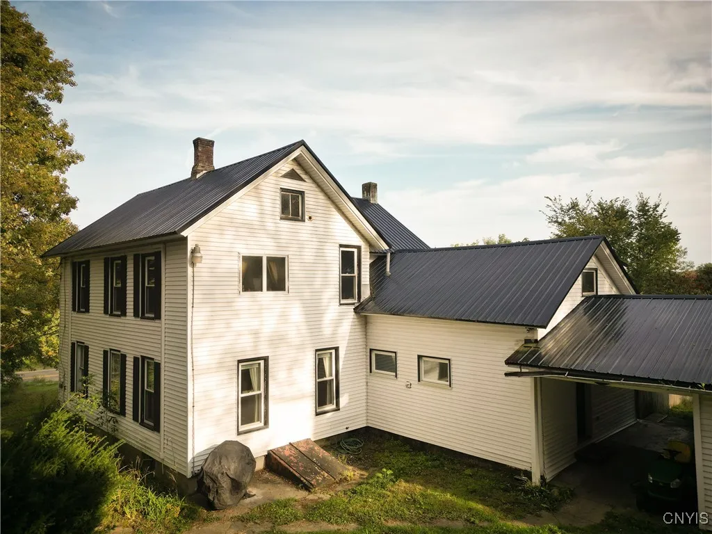 Back side of home with Breezeway that attaches the 2 car garage. New metal Roof!!