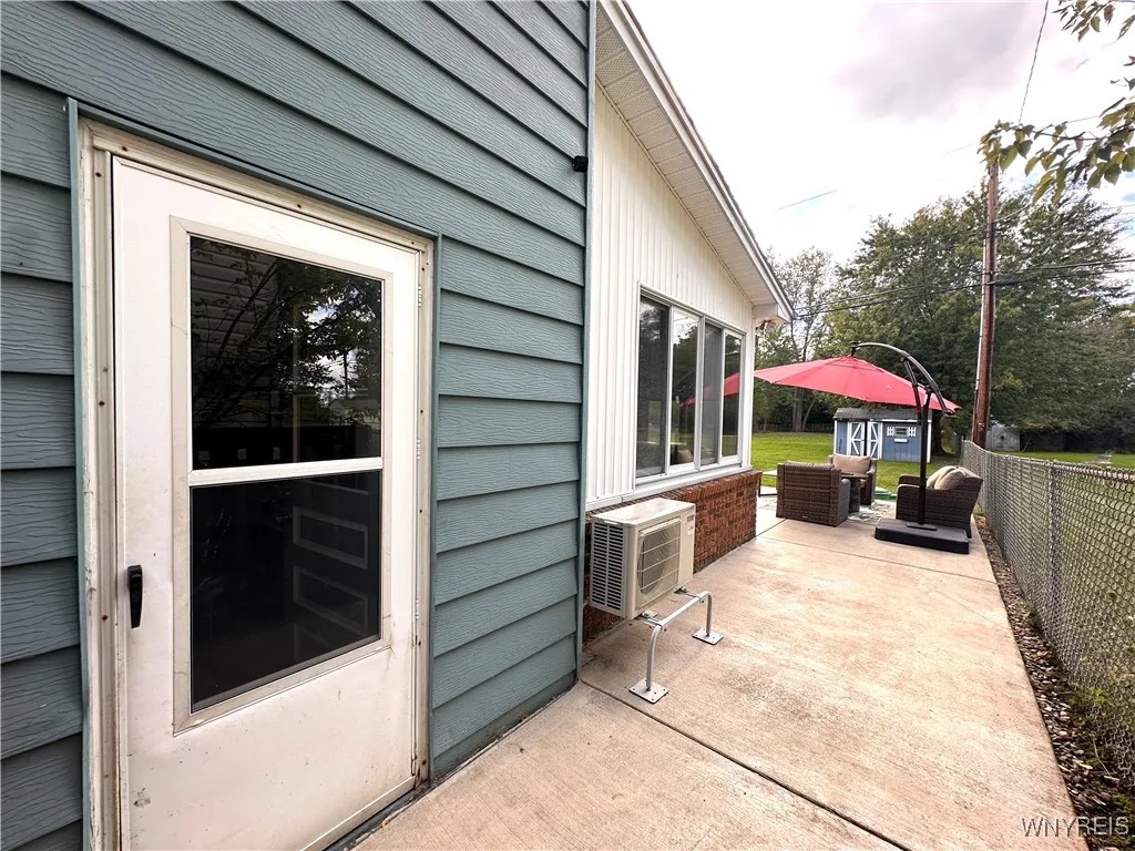 Side of the house with concrete walk to the back yard and A/C unit for back room
