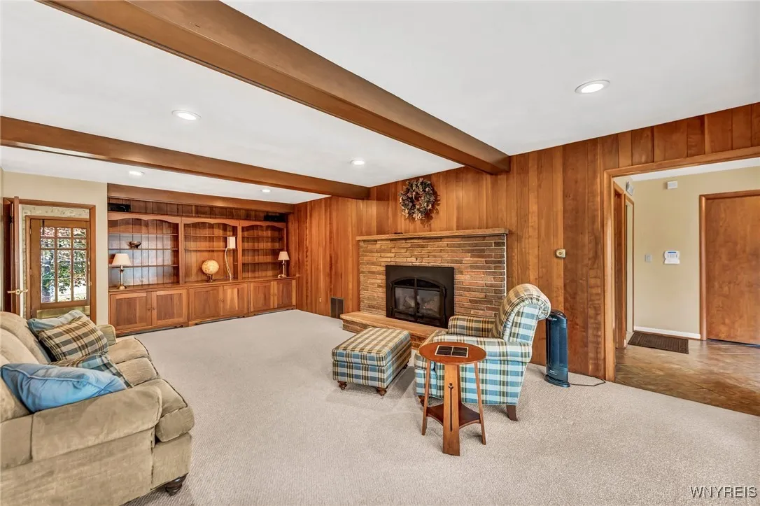 Beamed ceiling family room with gas insert fireplace and built-in cherry cabinets.