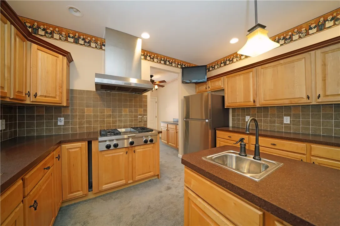 Kitchen with gas stove top, island w sink going to side door and, laundry and 1/2 bath