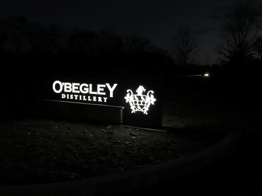 Monument sign along road that lights up at night.