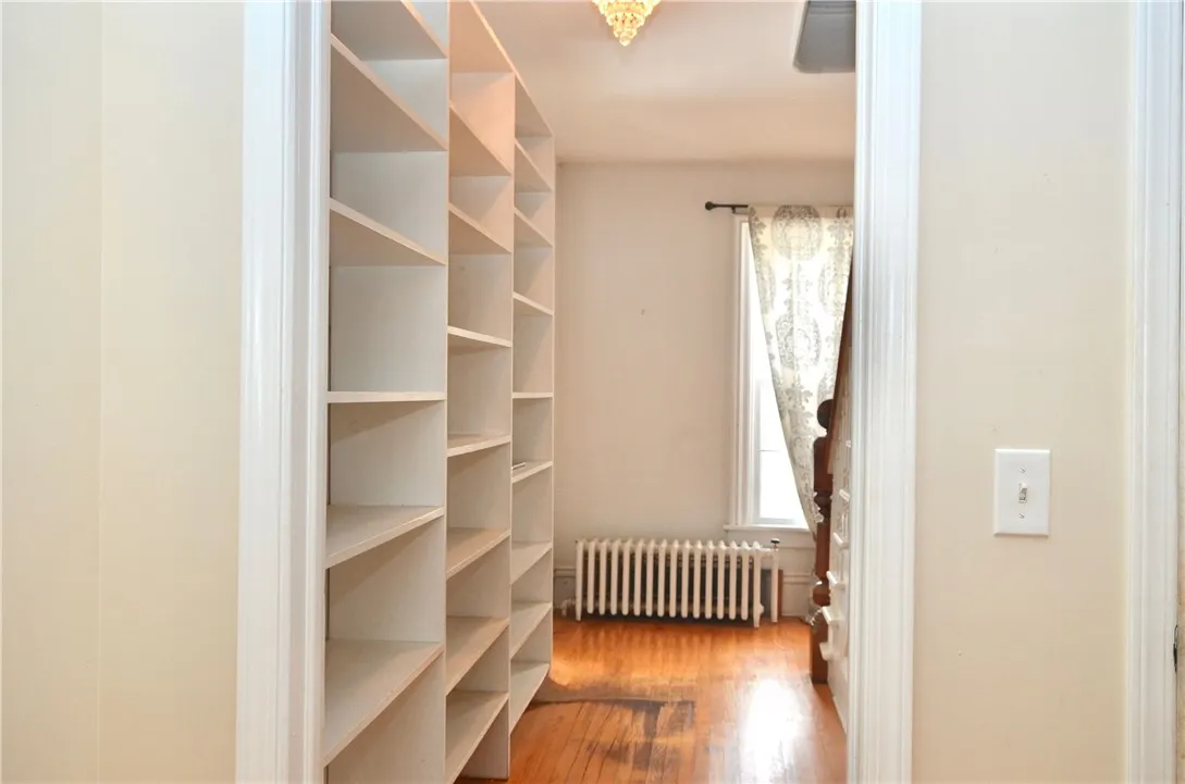 Hall between the living room and family room with immense shelving. ~15' x ~4'  (Measurements are approximate.)