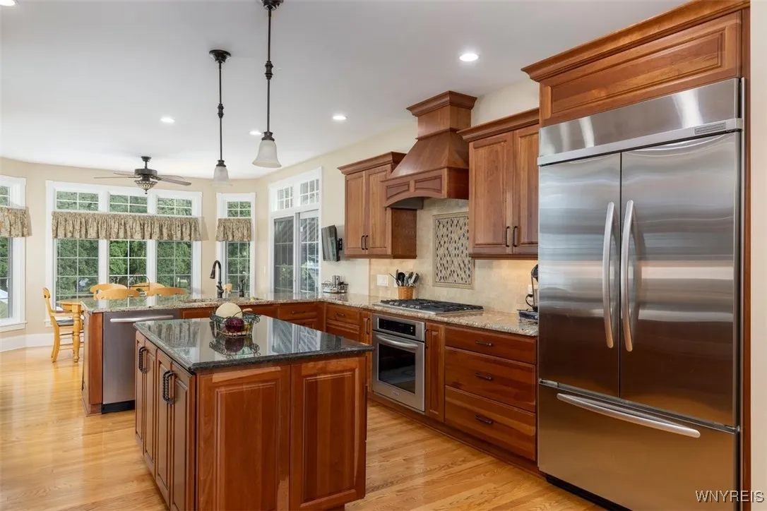 Updated kitchen from dining room, hardwoods continue, stainless steel appliances, gas cooktop, beautiful cabinetry. View of private rear yard from eating area.