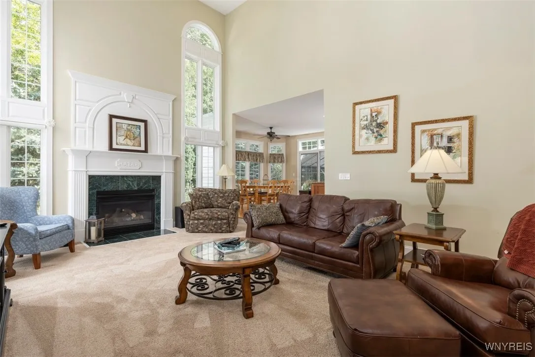 Family room with plush carpeting, gas fireplace, and two story insulated windows for tons of natural light.