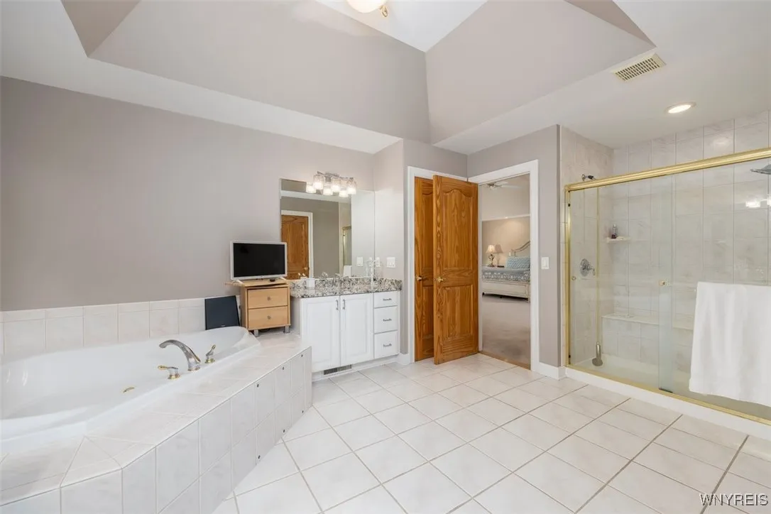 Tiled shower with bench, granite countertops and trey ceiling add to the glamour!