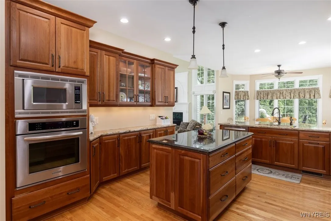 Additional wall oven with microwave, lighted display cabinets, granite countertops.