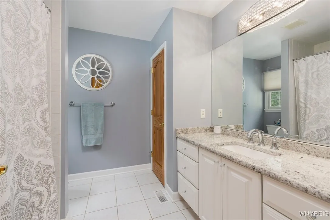 Updated guest bath with granite, tub and shower combo.