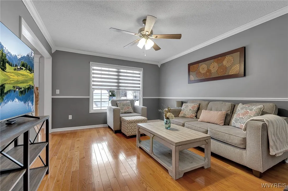 Dining room features ceiling fan hardwood flooring, chair rail and crown moulding