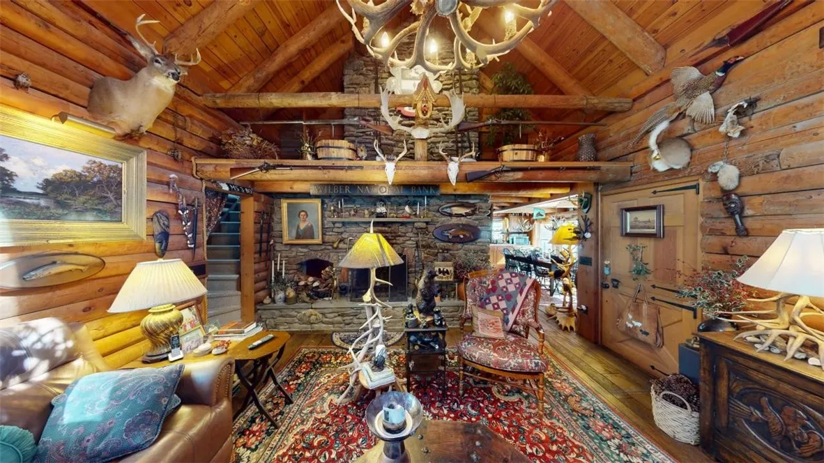 Note the small loft above the fireplace. Stairs to the left lead to the second floor. Lovely Dutch door on the right leads to the covered side porch. Dining area in the far distance.