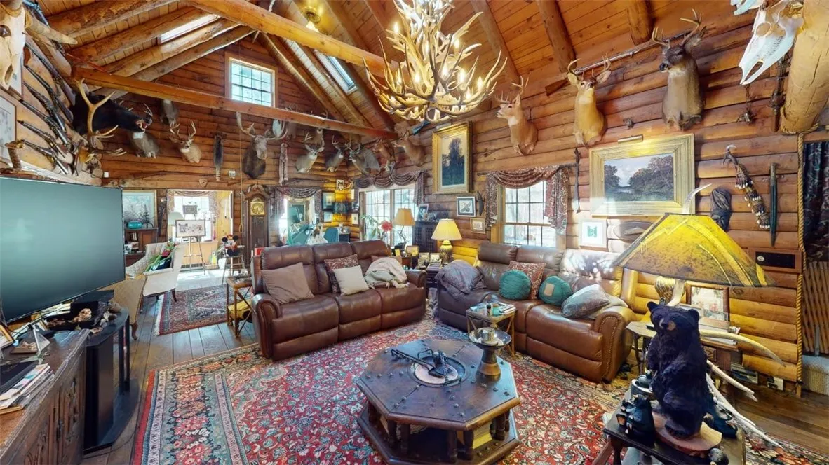 Living room.  In the far back another room, ideal for artist studio!  To the right, a set of sliding doors leads to a wonderful tiered deck with a stone fireplace, hot tub, and multiple seating areas.