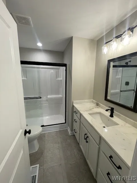 primary bathroom with walk in shower and quartz counter top