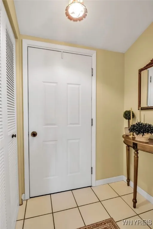 Ceramic tiled front foyer w/vaulted ceiling, coat closet + pretty light fixture