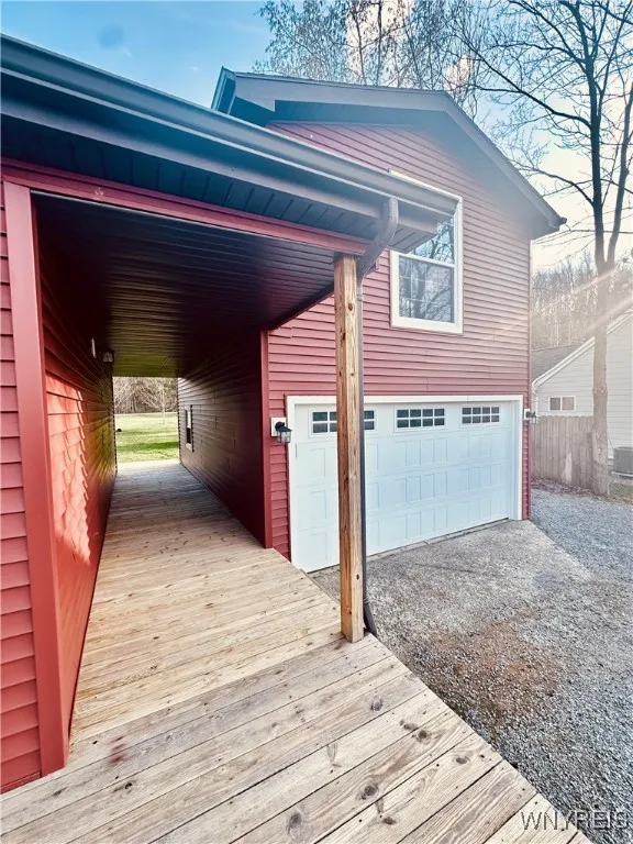 Covered breezeway between house and garage with pull down stairs for additional storage.
