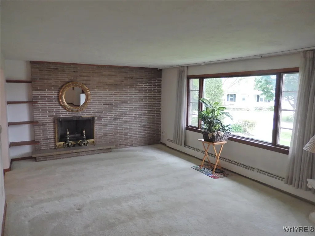 Living Room with fireplace and large window overlooking front yard.