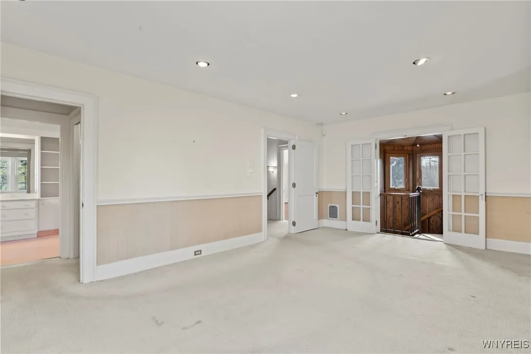 Primary bedroom with french doors to the spiral staircase
