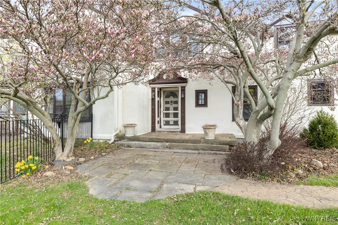 Front door with magnolia trees in bloom welcomes you.