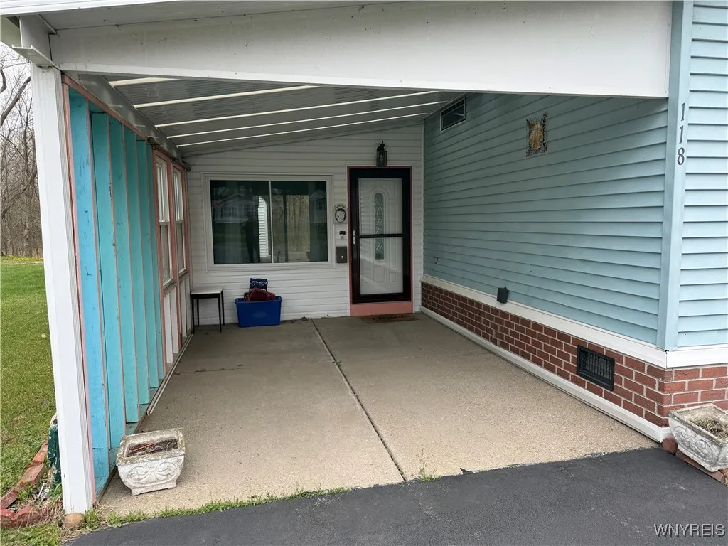 Large carport and parking for another car on driveway.