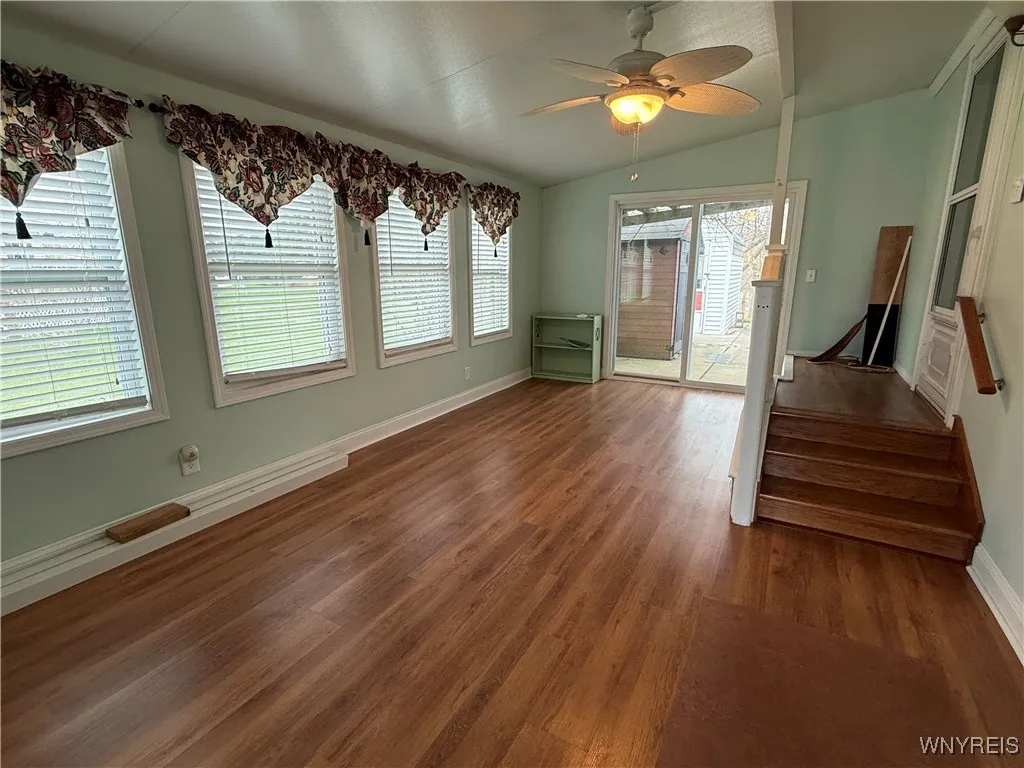 Large sunroom with sliding glass door to patio in rear.