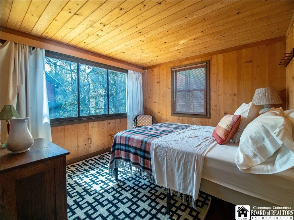 First floor bedroom with a large screen facing the back of the home.
