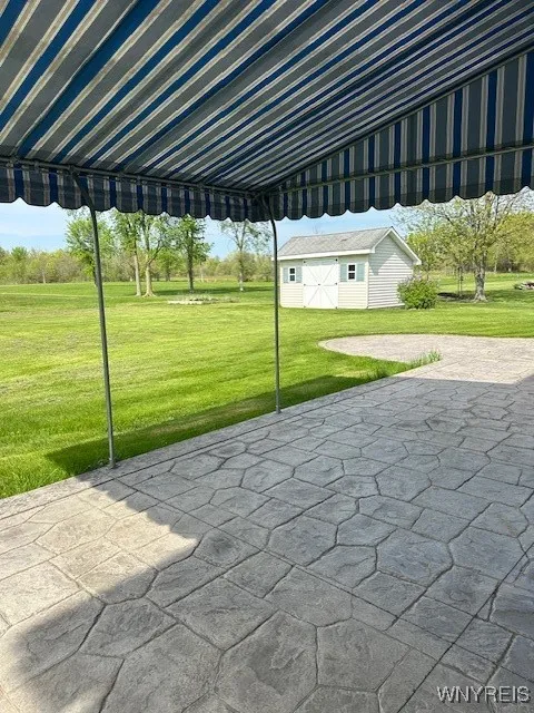 Rear stamped concrete patio with awning
