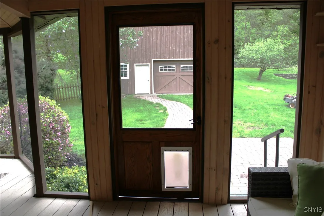 view from porch back door to patio and barn