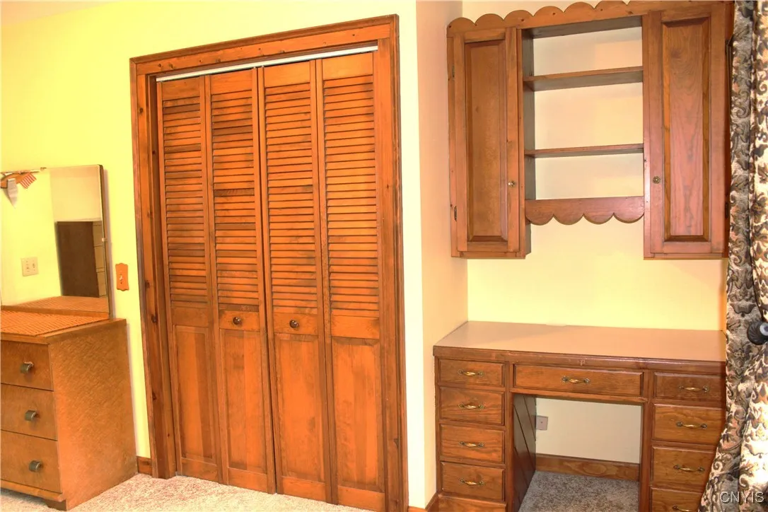 third bedroom with built in desk and shelves
