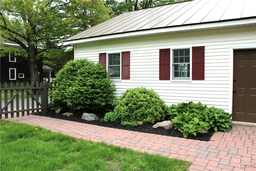 Walkway from patio to driveway along garage