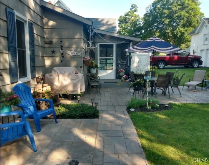 Rear entrance with stamp Crete walkway and many Urns of flowering annuals and gardens.