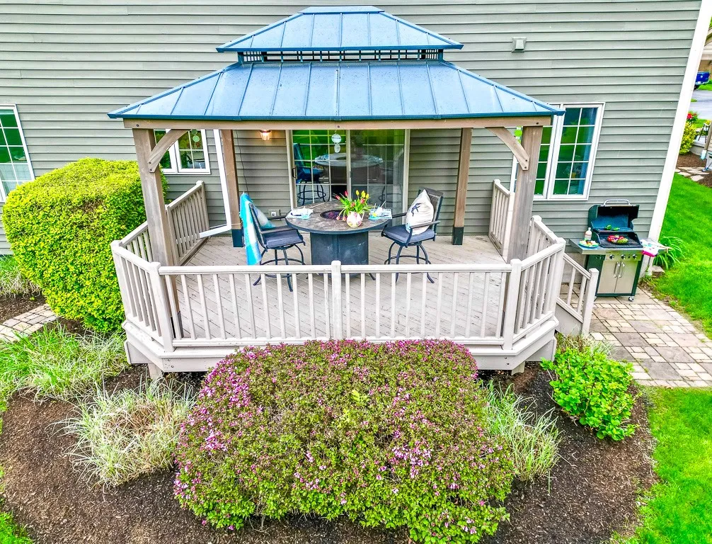 The deck, gazebo and  fire pit overlook the park-like setting with flowering trees and bushes that envelop the striking gazebo.