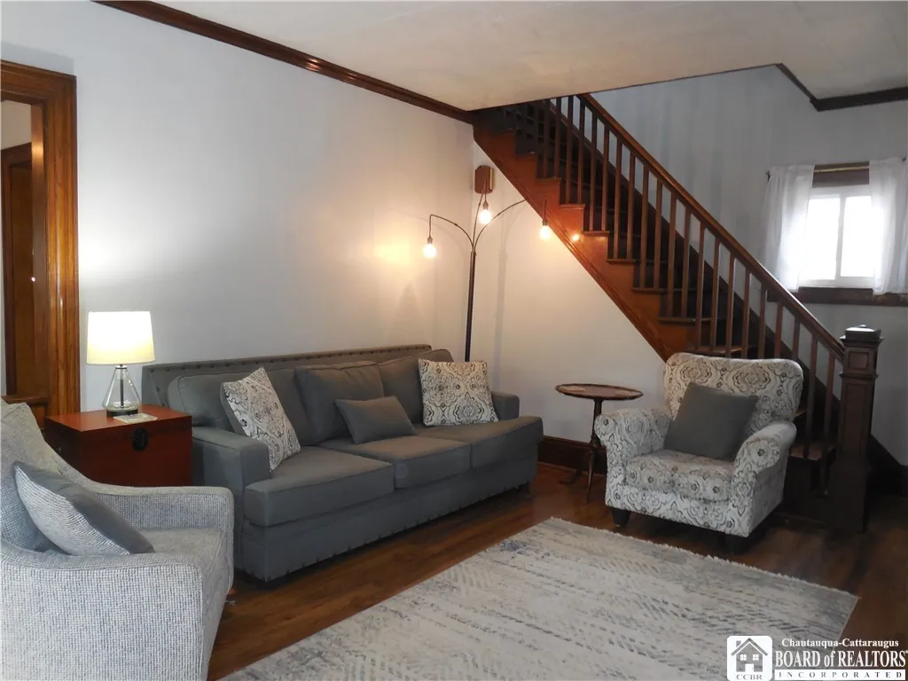 LIVING ROOM WITH SPINDLED STAIRCASE