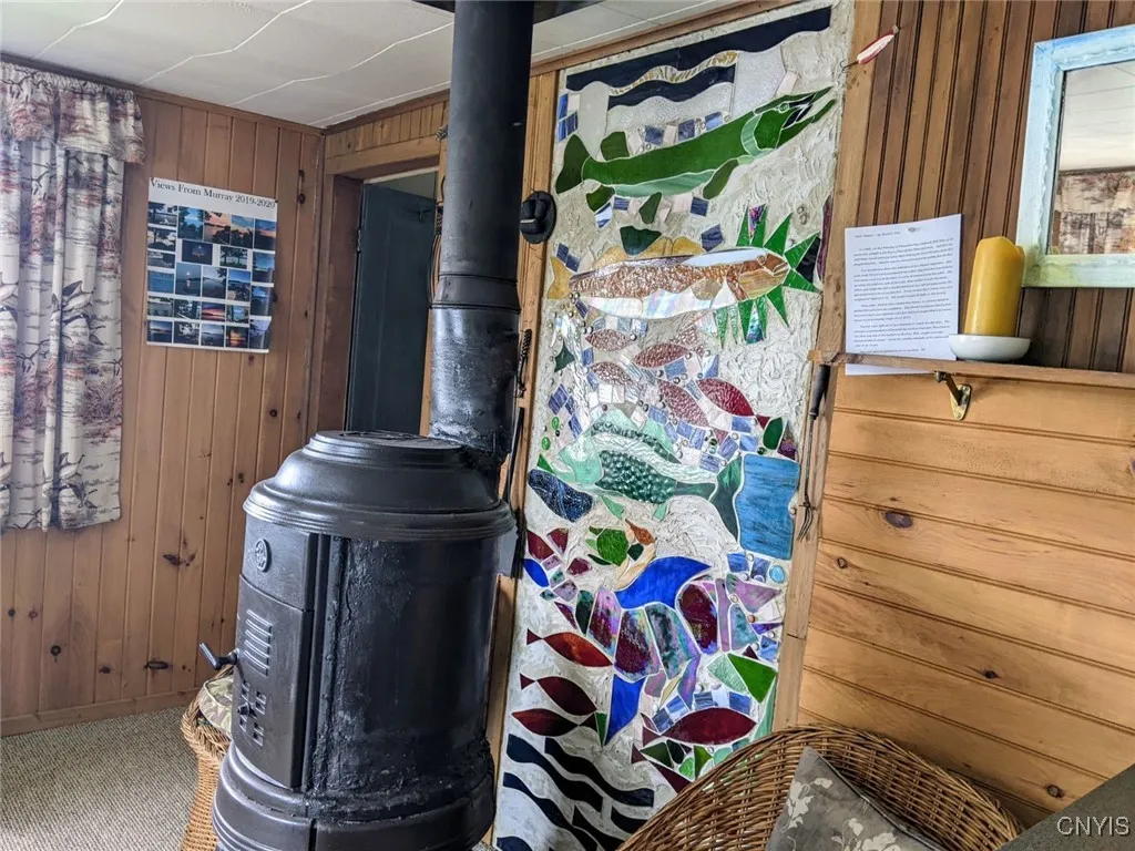 Unique stained glass fish art installation is behind woodstove.