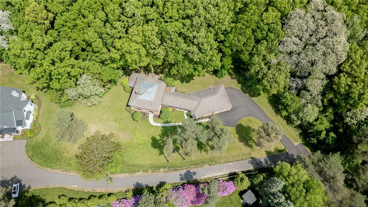 This private brick home boast a wooded secluded yard that backs up to Pittsford parkland.