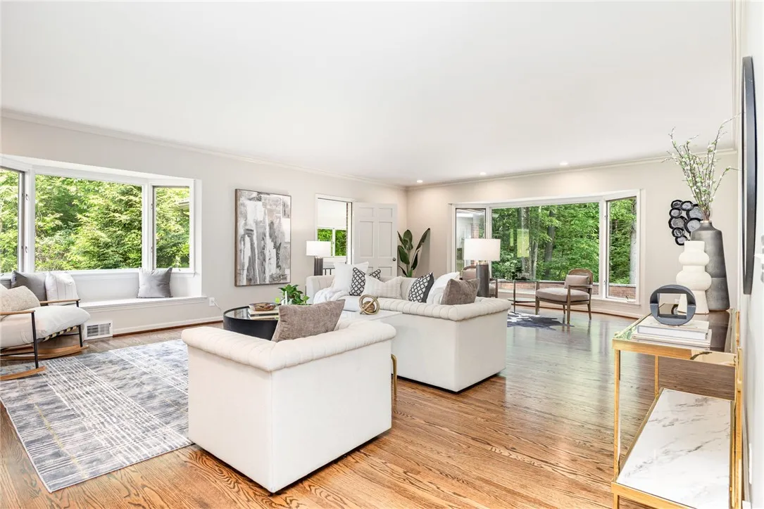 The living room has views of back and side yard, access to the three season sunroom, and dining room