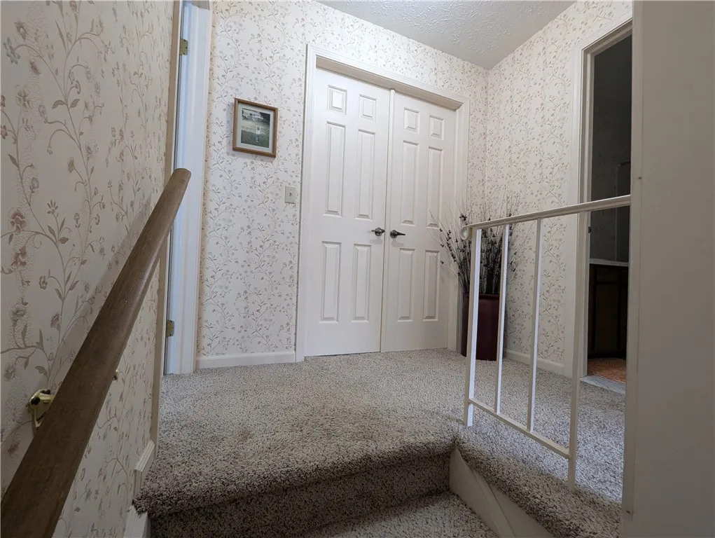 UPSTAIRS LANDING. PRIMARY BEDROOM W/ FRENCH DOORS. 2ND BEDROOM ON THE LEFT. HALLWAY FULL BATHROOM ON THE RIGHT.