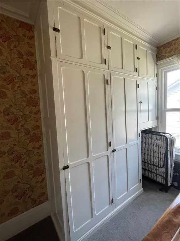 Upstairs built-in linen storage with closet and laundry shoot.