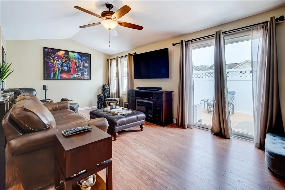 Living room with elegant cathederal ceiling leads to patio